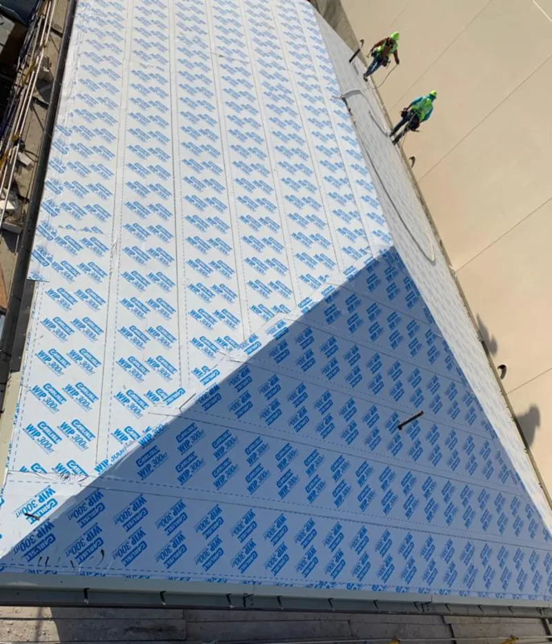 Professional roofers installing underlayment on a metal roof in Granby